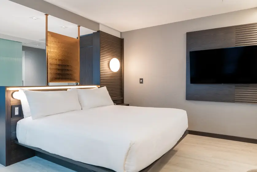 Modern guest room with king-size bed, wall-mounted TV, and contemporary furnishings at Burlington Square