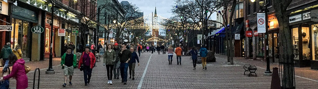 Church Street Marketplace pedestrian promenade with shoppers, local storefronts, and festive lights in downtown Burlington