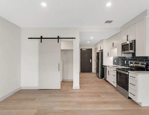 Modern open-concept apartment interior with kitchen, stainless steel appliances, and spacious living area at Burlington Square Apartments