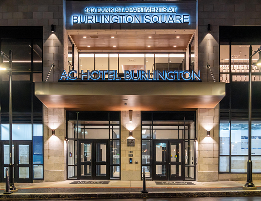 Entrance of AC Hotel Burlington at Burlington Square illuminated at night in downtown Burlington