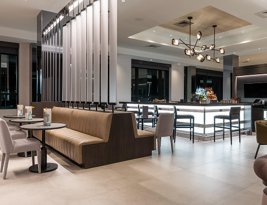Modern hotel lounge and bar area at AC Hotel Burlington featuring contemporary seating and elegant lighting